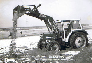 Hein van der Putten op strand met de tractor